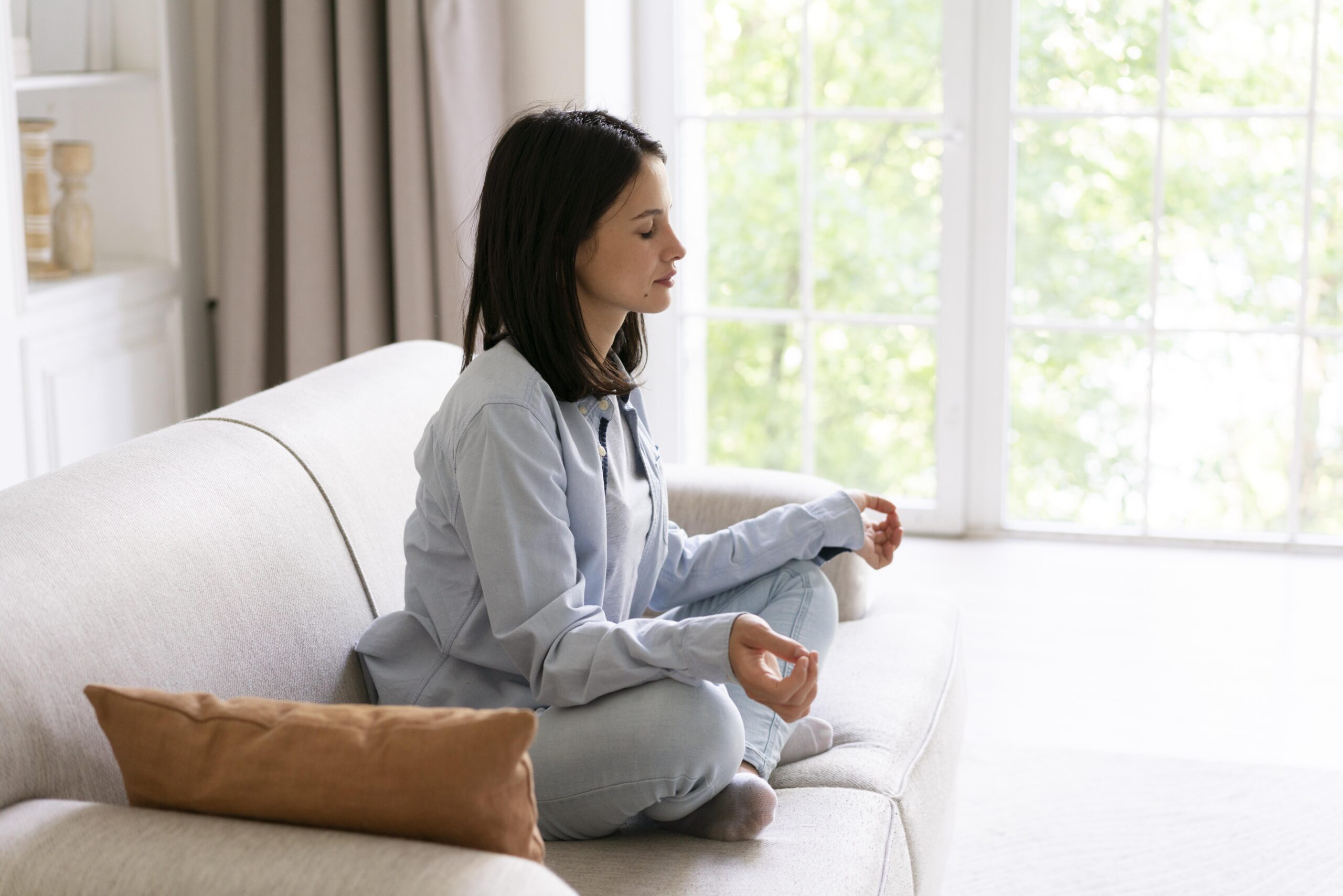 Woman meditating on sofa